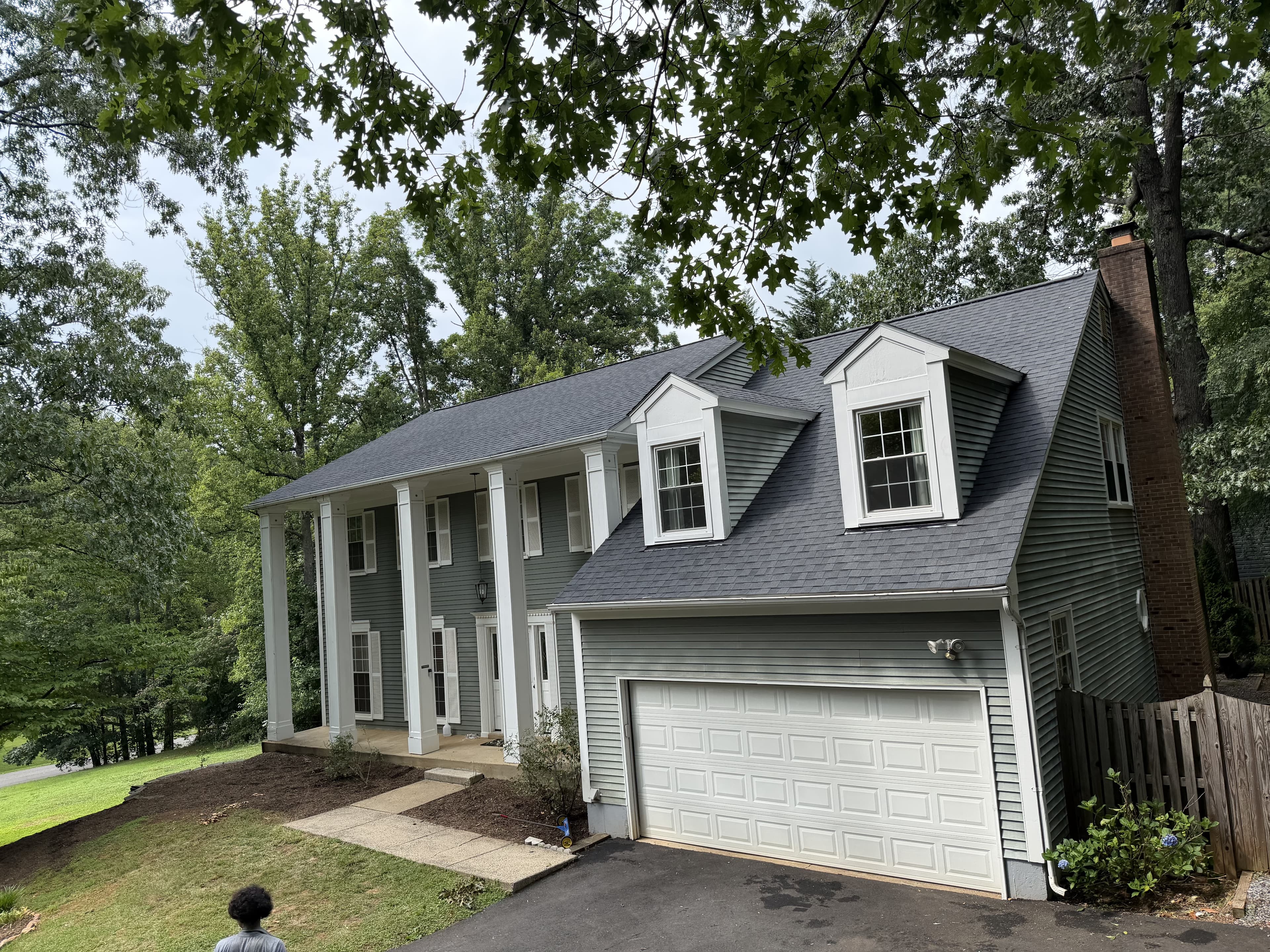 Finished dark gray architectural shingle roof on a two-story colonial home