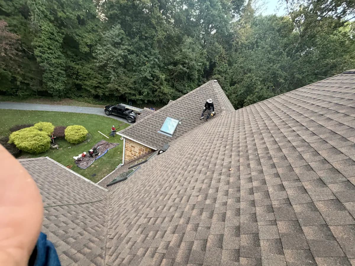 Roofing work around a skylight on an asphalt shingle roof in McLean