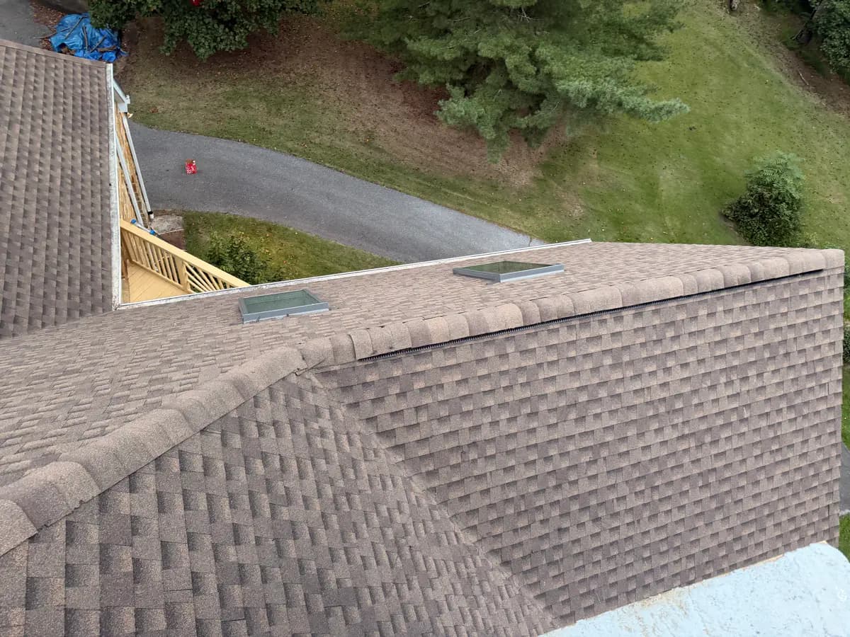 Finished ridge caps and skylights on an asphalt shingle roof in McLean