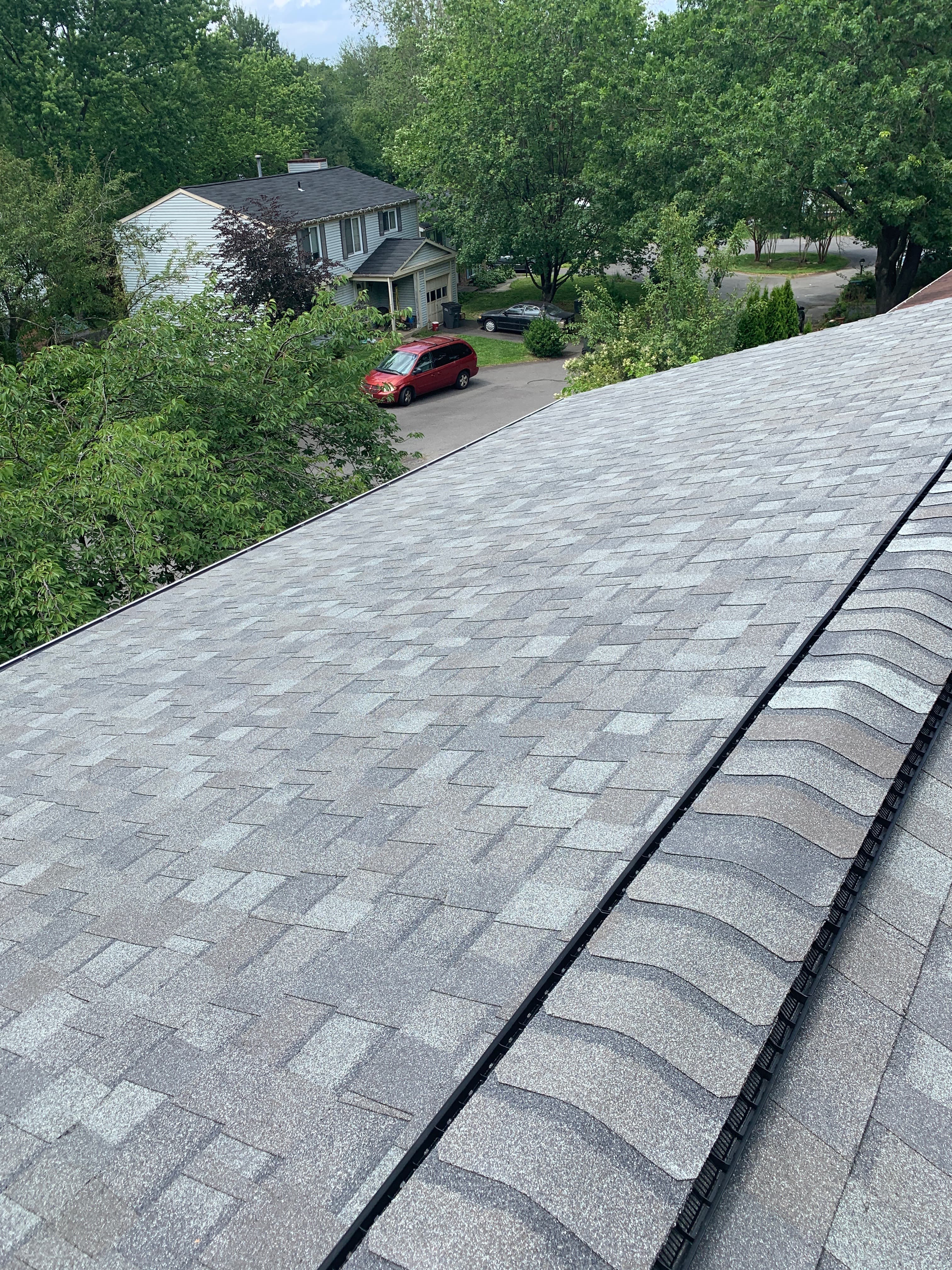 Close view of the ridge line on a finished gray architectural shingle roof in Herndon